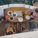 Luxury catamaran cruising on open water with a modern city skyline, ideal for private yacht rental and sea celebrations.