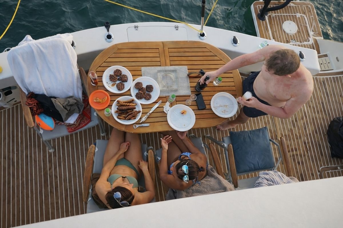 Luxury catamaran cruising on open water with a modern city skyline, ideal for private yacht rental and sea celebrations.