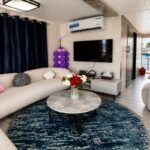 Elegant houseboat accommodation with contemporary interiors, private terrace, and peaceful marina surroundings.
