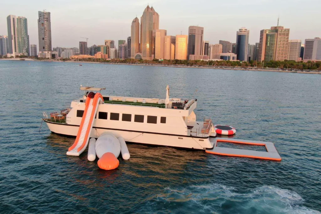 Butinah Boat with water slide, trampoline and sea pool, Abu Dhabi skyline