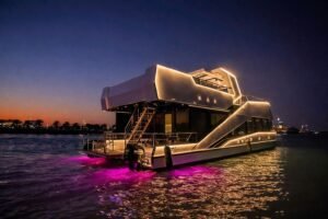 Celestia yacht rental lit up at night with LED outline and underwater lights, Yas Marina, Abu Dhabi